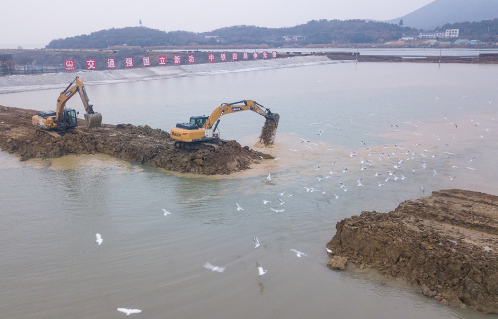 2019年12月23日，鳥群從陸島轉(zhuǎn)換圍堰回水施工現(xiàn)場飛過。